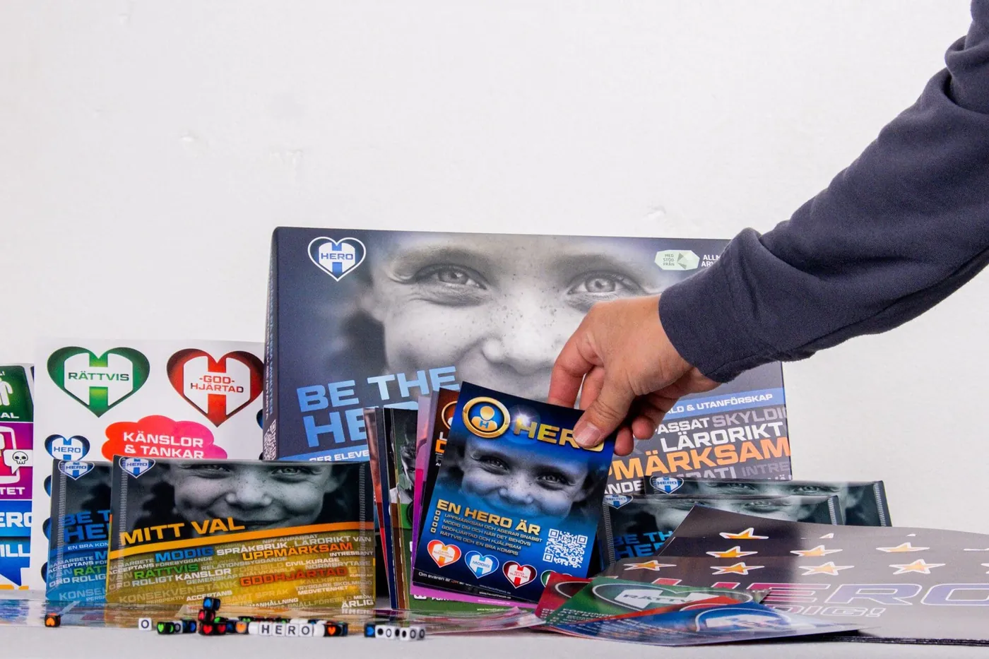 Öppen HERO BOX med 18 illustrerade HERO-kort, affischer och klistermärken